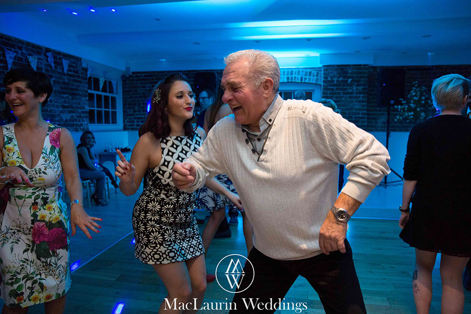 dancing wedding guests a man in his 60's giving the younger guests some moves