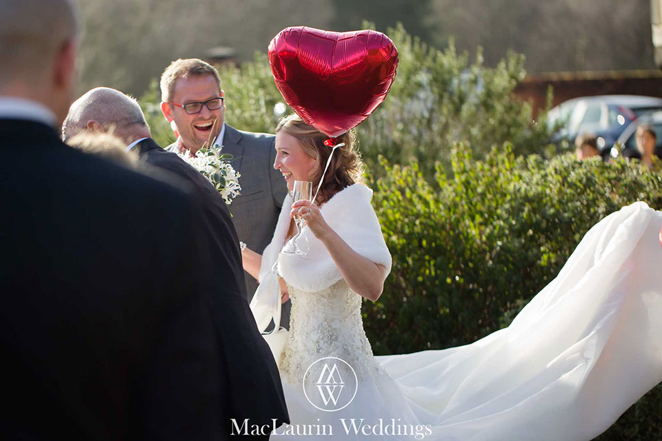 happy bride with love heart a happy bride walks with guests holding a loveheart baloon