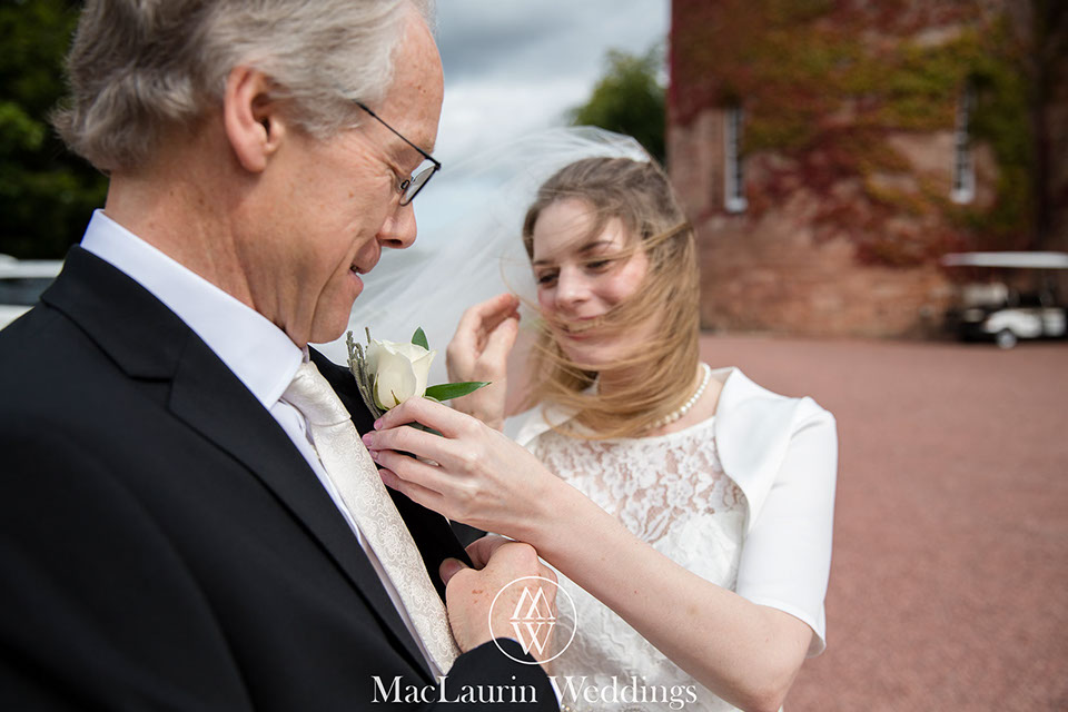 happy bride with her father dalhousie castle scotland a happy bride adjusting her fathers  buttonhole dalhousie castle scotland