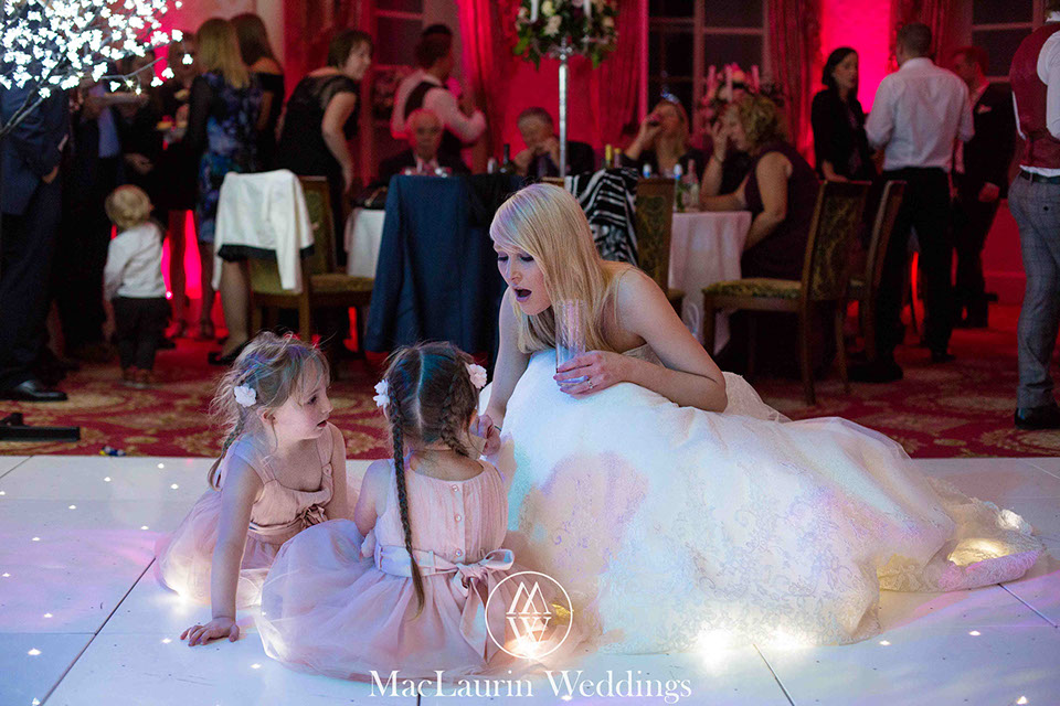 bride on the dancefloor a bride chatting with two girls on the dancefloor