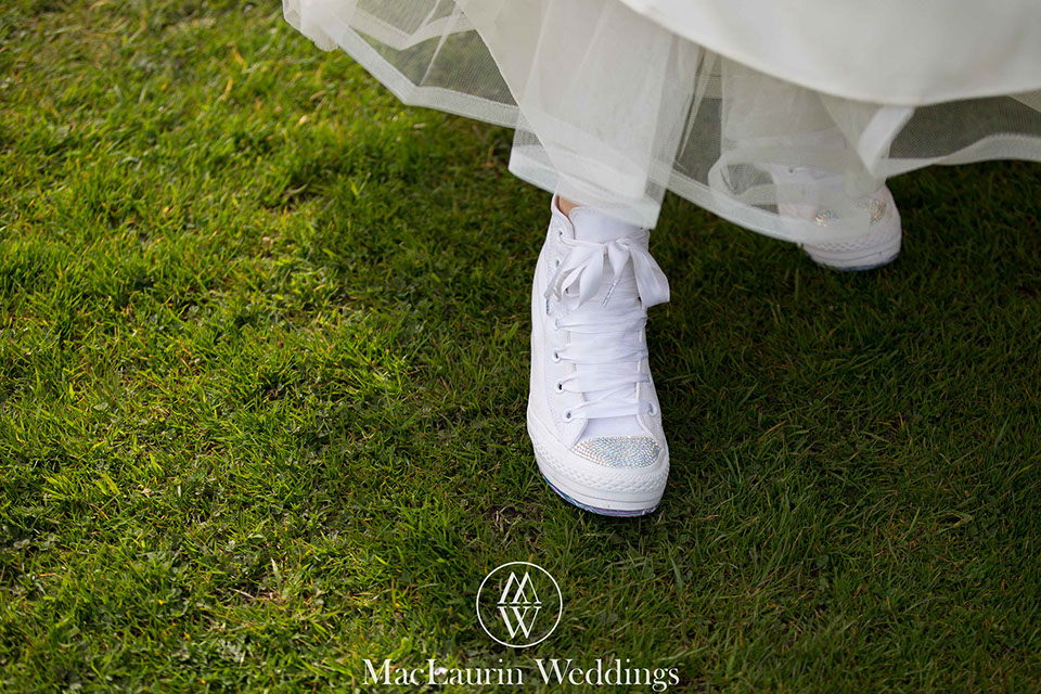 bride wears sparkly shoes a bride is wearing sparkly converse on grass